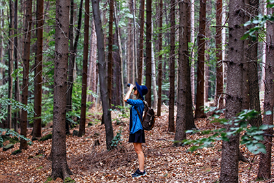 Woman birding in the forest with binoculars